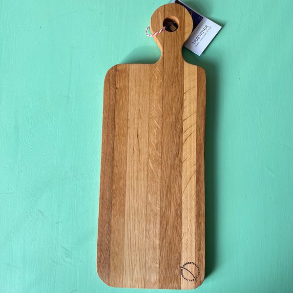 langt tapasbræt i lyse træsorter med håndtag, svage striber